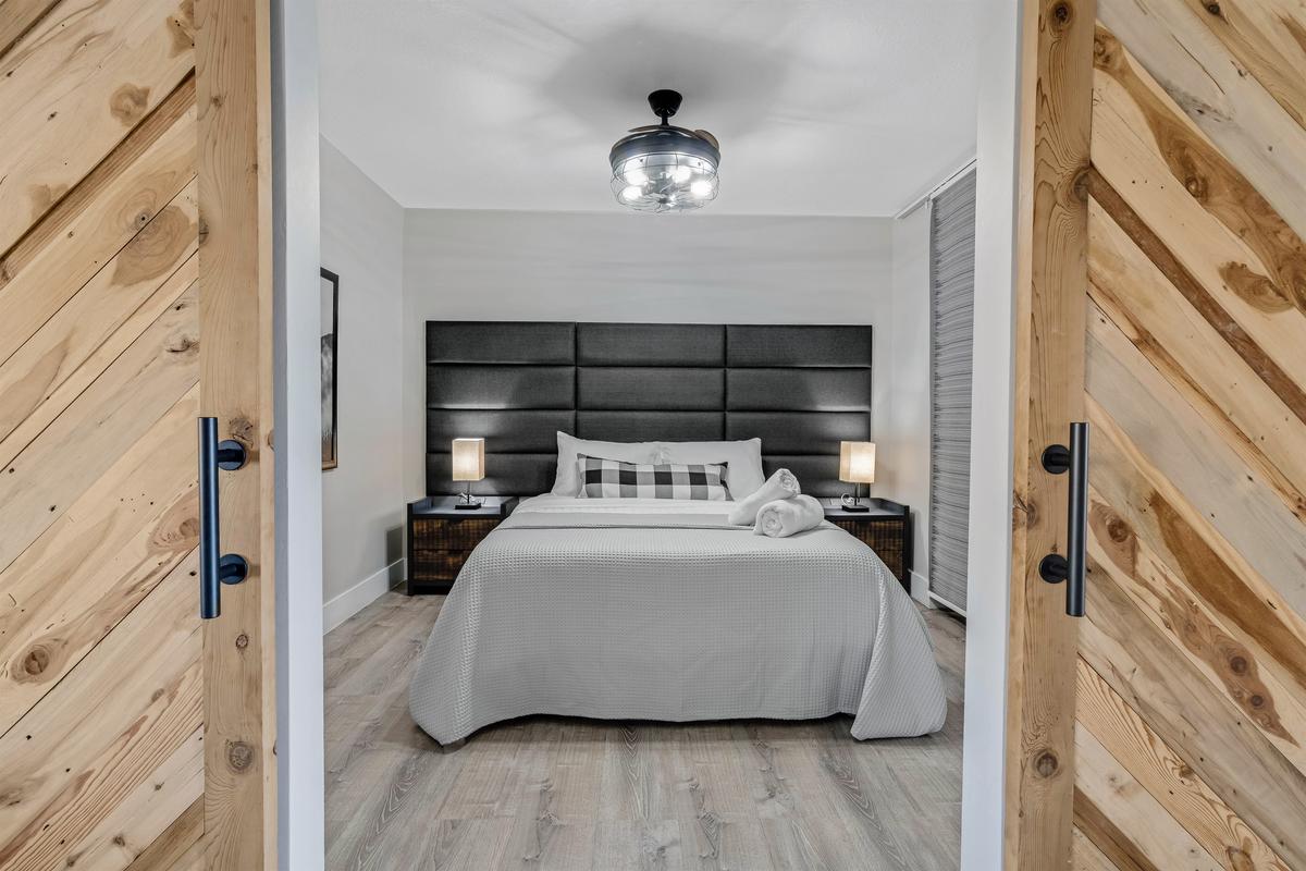 🛌 Cozy queen room with clean lines and easy access to the shared bath.